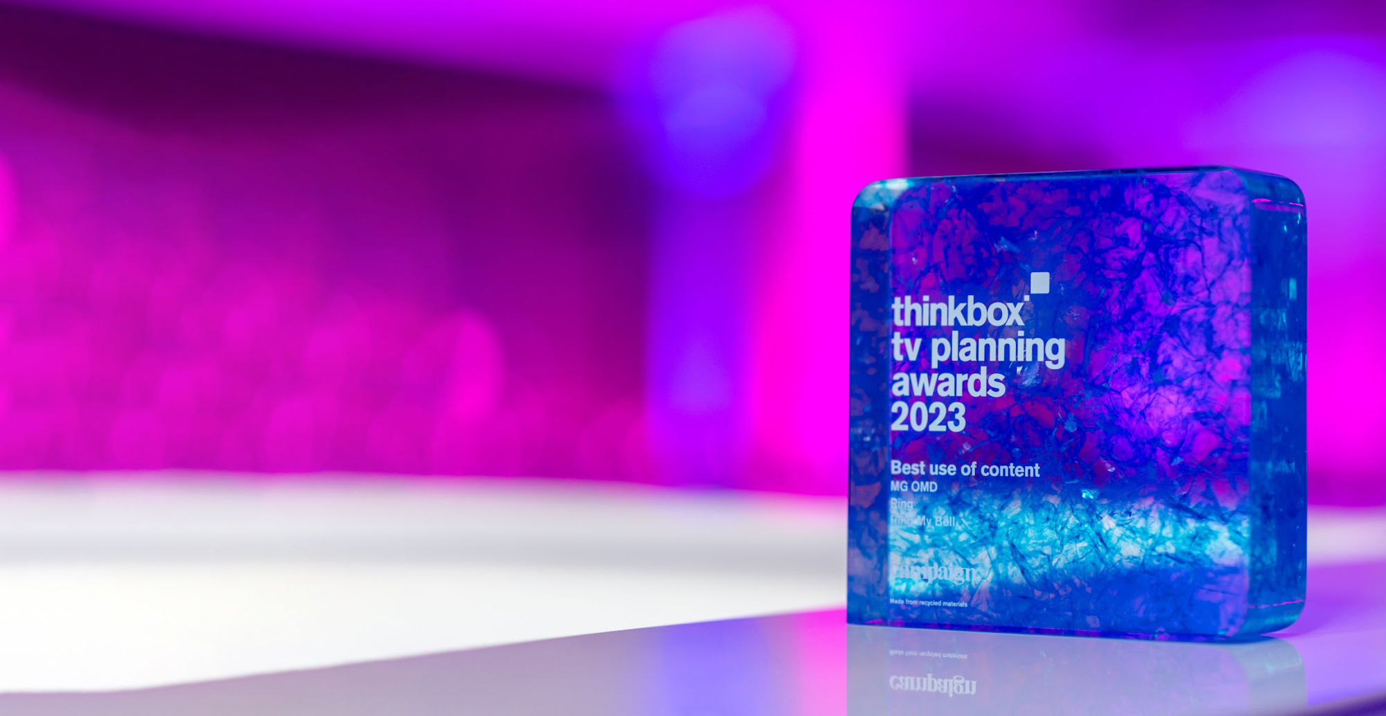 A vibrant, translucent recognition awards with a blue and purple marbled pattern sits on a glossy surface. it's labeled