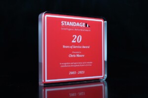 Financial tombstones for 20 years, labeled "standage intelligent refurbishment", recognizing chris moore, displayed against a black background. dates 2003-2023 are noted at the bottom.