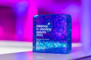 The Thinkbox TV Awards held at One Marylebone Road, 12th July 2023Photography by Fergus Burnett A vibrant, translucent recognition awards with a blue and purple marbled pattern sits on a glossy surface. it's labeled "thinkbox tv planning awards 2023 - best use of content." soft purple lighting in the background.