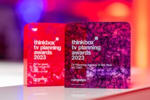 The Thinkbox TV Awards held at One Marylebone Road, 12th July 2023Photography by Fergus Burnett Two vibrant recognition awards from the thinkbox tv planning awards 2023 are displayed against a red and purple blurred background. the left award is red, and the right displays a detailed purple design.