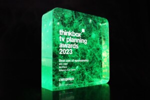 A translucent green recognition award with internal intricate patterns, illuminated from below. text on the award includes "thinkbox tv planning awards 2023", "best use of sponsorship", and other details.