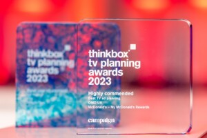 The Thinkbox TV Awards held at One Marylebone Road, 12th July 2023Photography by Fergus Burnett Two transparent acrylic recognition awards on a red background; the left is blue and labeled "thinkbox tv planning awards 2023," the right mentions "highly commended" to omd uk by campaign for mcdonald's.