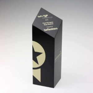 A black triangular marketing recognition award from "turf's top influencer" for paul burgess at real madrid by turf business, featuring gold and white text and a prominent star logo.