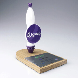 Deal toys featuring a wooden base with a metal plaque, supporting a white and purple oval-shaped logo on a spinning axis. the design is sleek and modern.