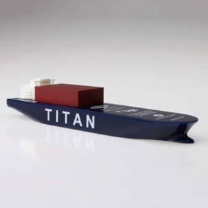 A deal toys model of the oceangate submersible named titan, showcasing its sleek, dark blue design with a large red and white section resembling cargo on a plain white background.