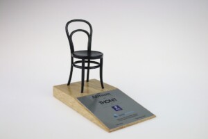 Deal toys model of a thonet chair displayed on a wooden base with an informational plaque, against a plain white background.