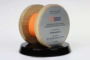 Commemorative spool-shaped deal toys with details of a financing event for deutsche giganetz, including amounts and advisers names, mounted on a black base, taken in july 2022.