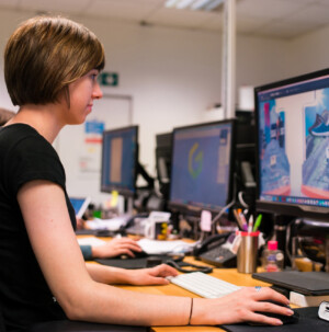 Deal toys designers sitting at her screen with design on the screen