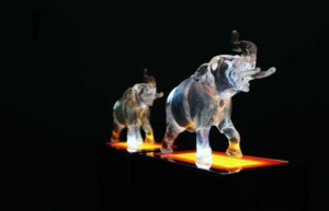 two clear acrylic elephant deal toys with yellow orange base