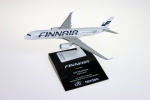 A scale model of a Finnair airplane mounted on a black stand with a plaque displaying the deal toys information and sponsor logos for citi and nordea.