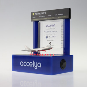 Deal toys featuring a model airplane in front of a mini departure board, both branded with "accelya," announcing a corporate acquisition by vista.