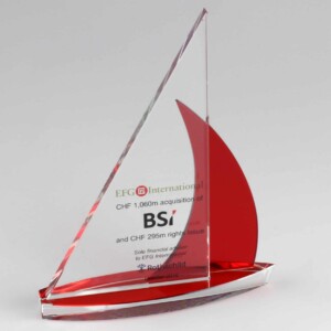 Clear and red glass financial tombstones shaped like a sailboat, with text commemorating efg international's acquisition of bsi and a rights issue in october 2016.