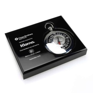 Black acrylic financial tombstones with a metal compass in a pocket