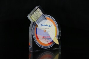 Clear acrylic financial tombstones shaped into a painting brush and disc shape with the text and logo printed on a colourful background