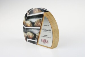 Semi-circular deal toys with a wooden base featuring a printed image of bread loaves on shelves and an adjacent metallic plaque with text and logos.