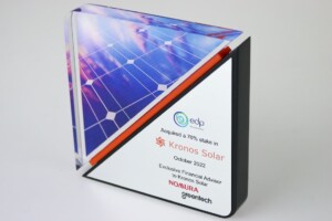 Acrylic financial tombstones celebrating kronos solar's acquisition by edp, with solar panel imagery and company logos displayed prominently.