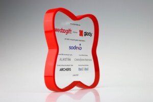 Red, tooth-shaped financial tombstones with multiple company logos printed inside, including "sodexo" and "gladly," on a reflective grey surface, dated june 2021.